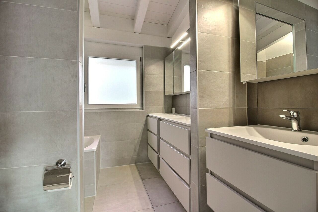 Modernes Badezimmer mit hellen Fliesen und Doppelwaschtisch