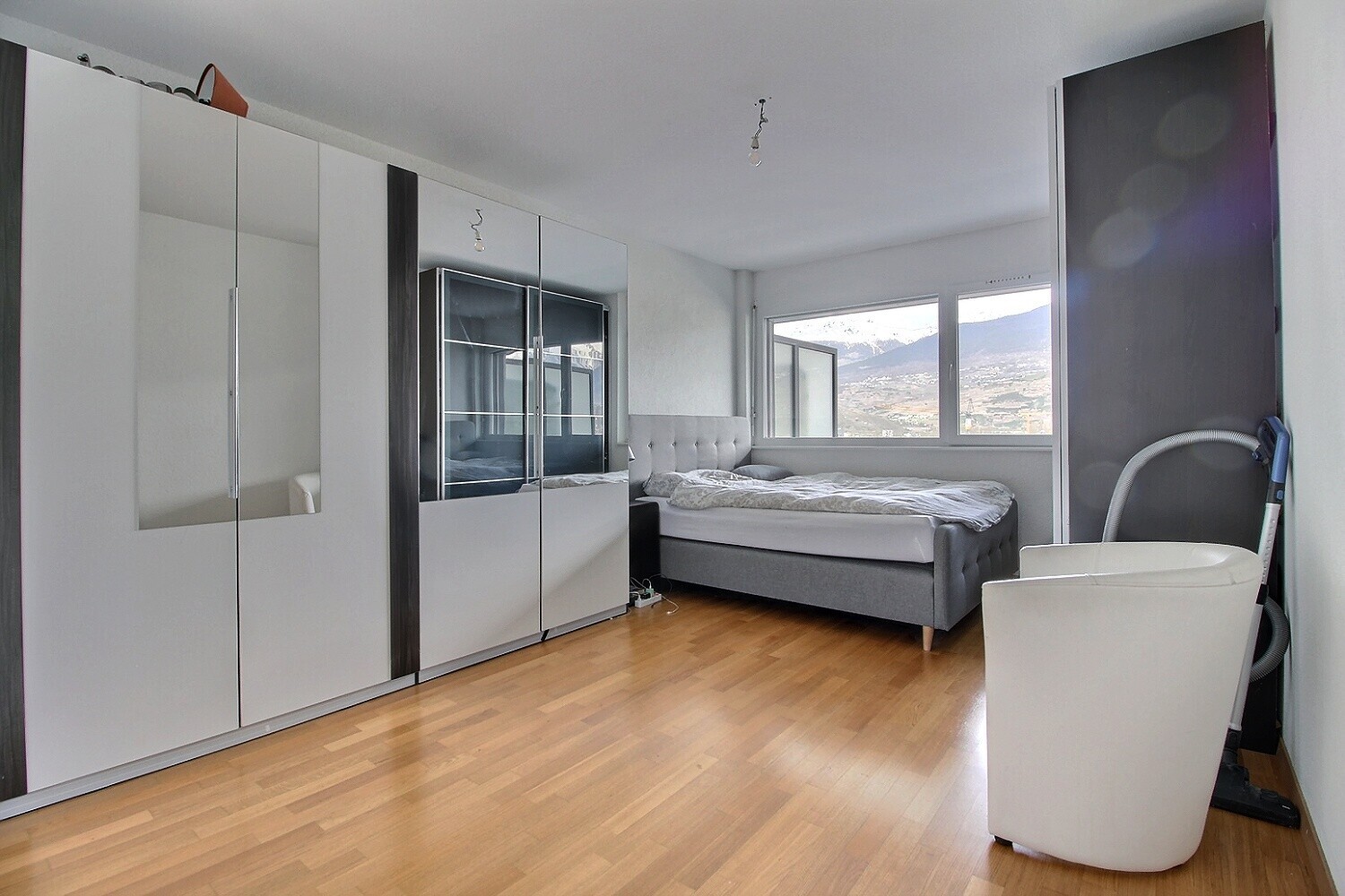 Modernes Schlafzimmer mit Kleiderschränken und Bergblick