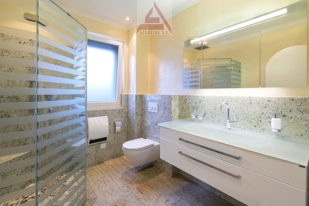 Modernes Badezimmer mit Glasdusche und Waschtisch