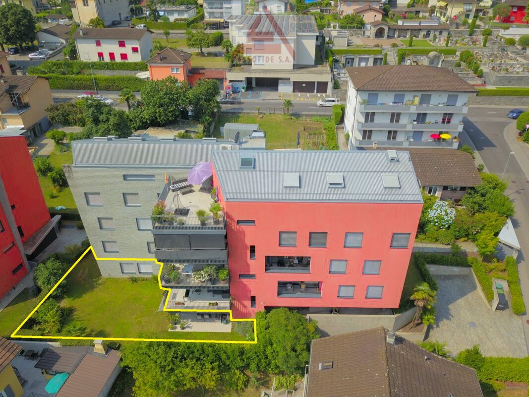 Luftaufnahme eines Mehrfamilienhauses mit markiertem Grundstück