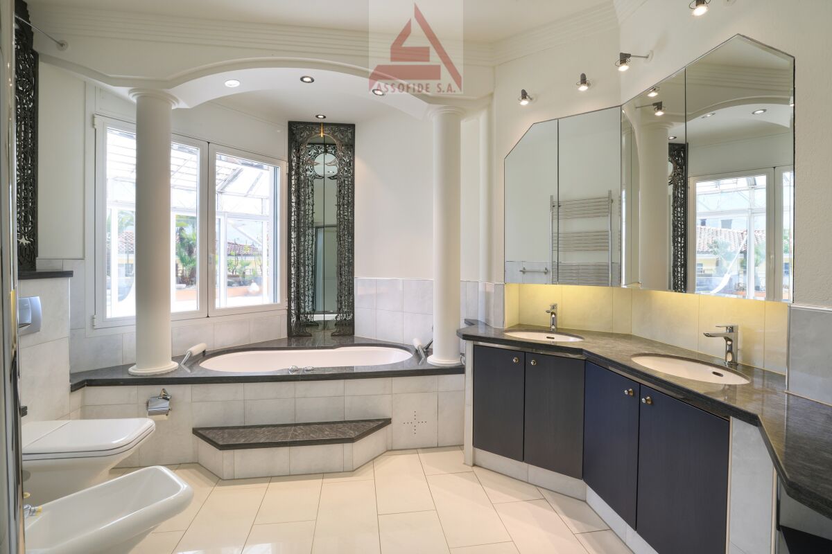Helles, elegantes Badezimmer mit Doppelwaschtisch und Whirlpoolwanne