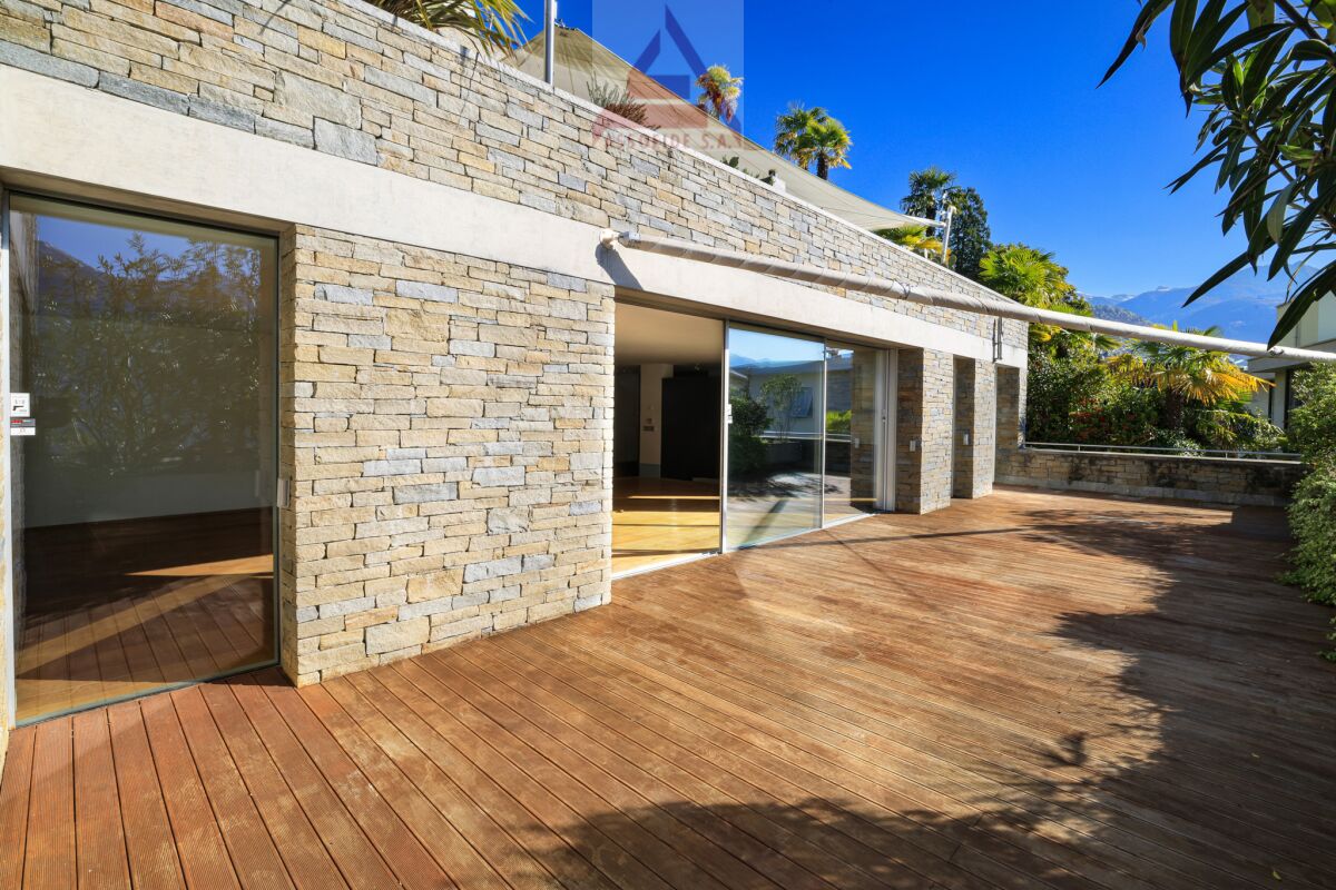 Terrasse mit Natursteinfassade und Holzdeck