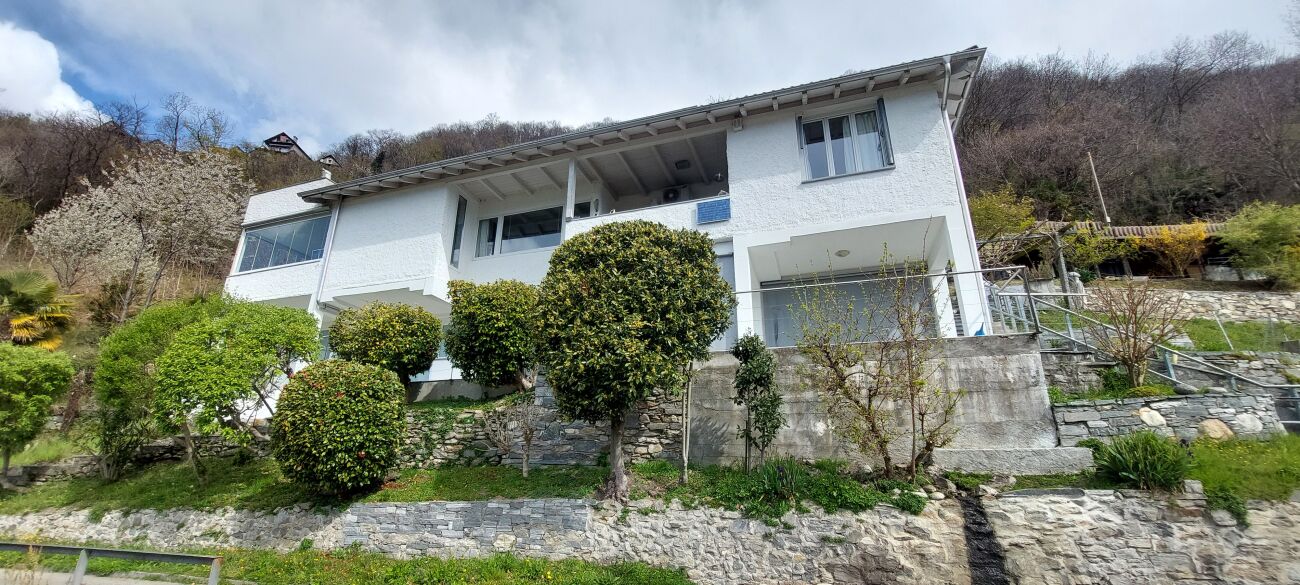 Weißes Wohnhaus mit Hanglage und Garten