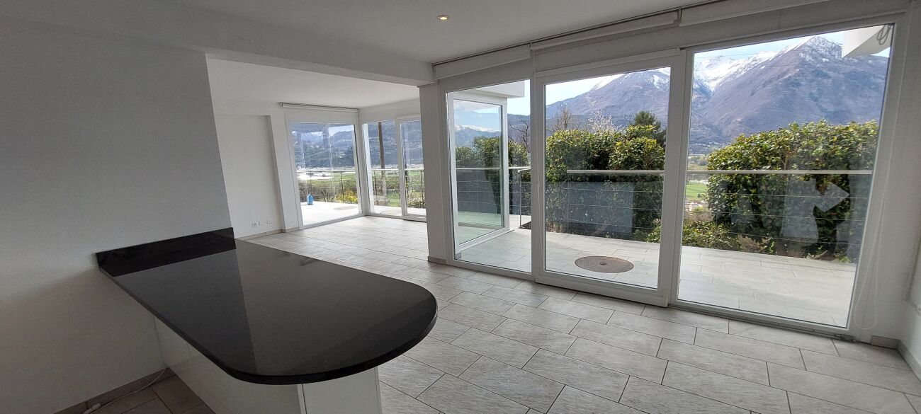 Heller Wohnraum mit Panoramafenstern und Bergblick