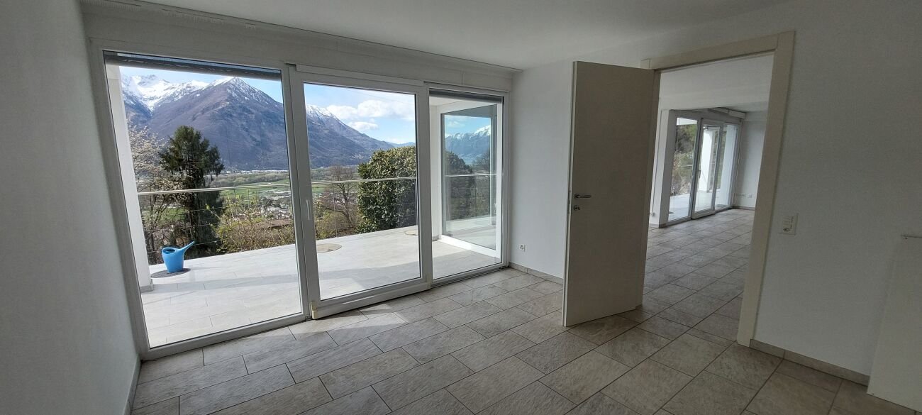 Heller leerer Raum mit großer Verglasung und Bergblick