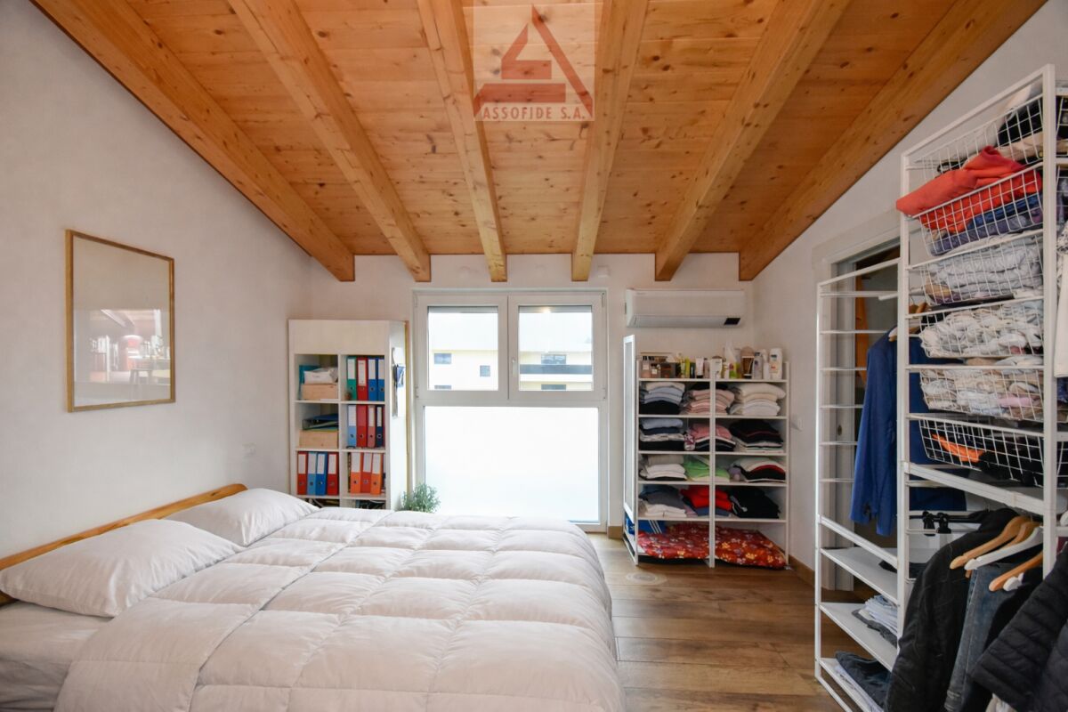 Schlafzimmer mit Holzdecke und Ankleidebereich
