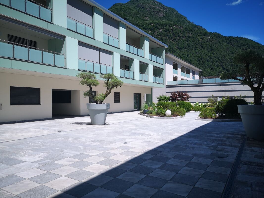 Moderner Innenhof mit Terrassen und Bergkulisse