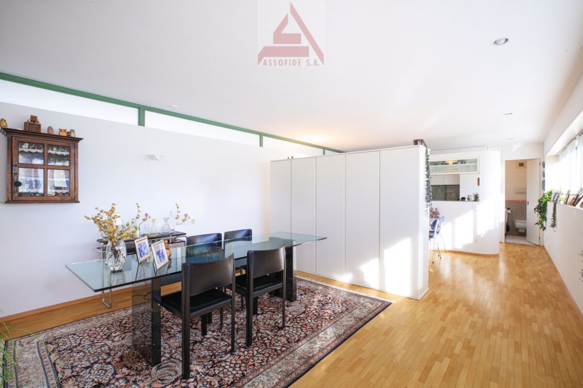 Essbereich mit Glasstisch und hoher Decke