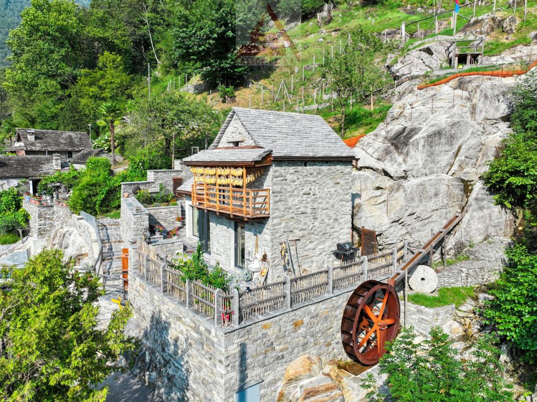 Steinhaus am Hang mit Wasserlaufrad