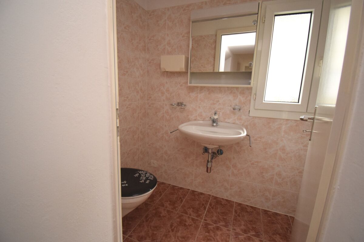 Kleines Badezimmer mit Waschbecken und WC