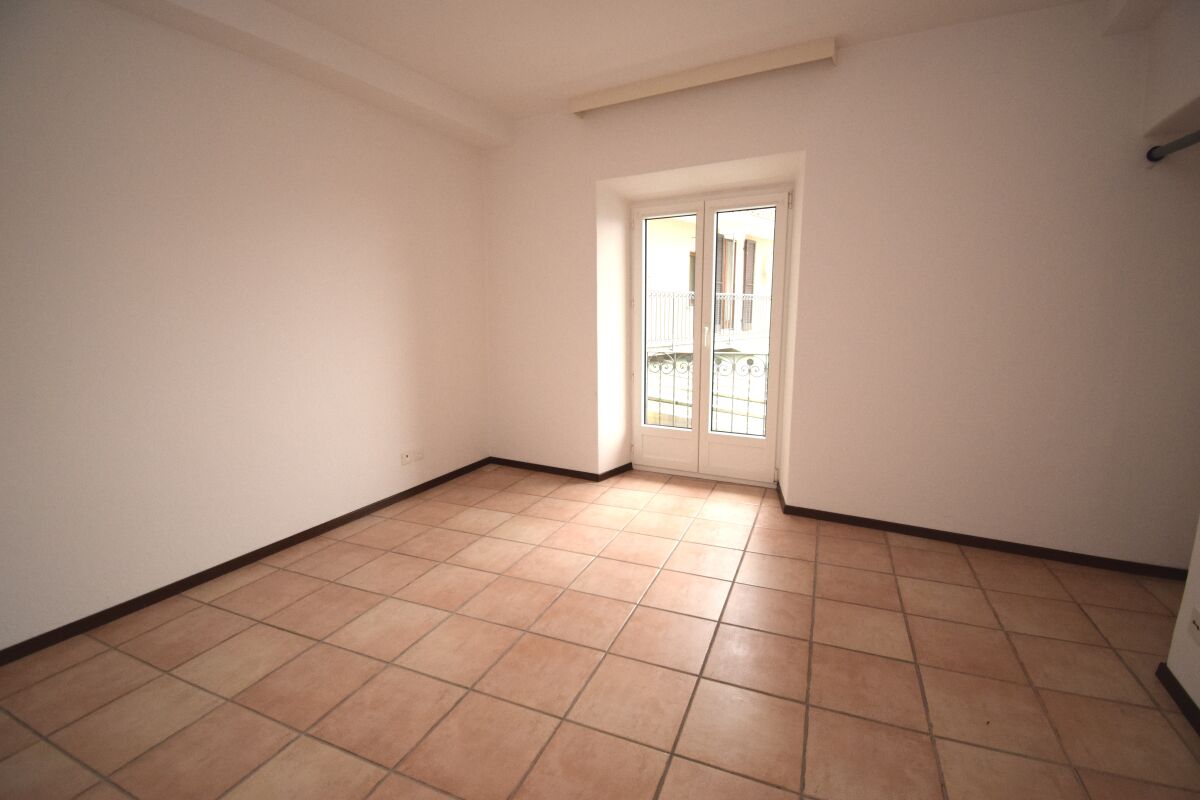Leerer Raum mit Fliesenboden und Balkontür