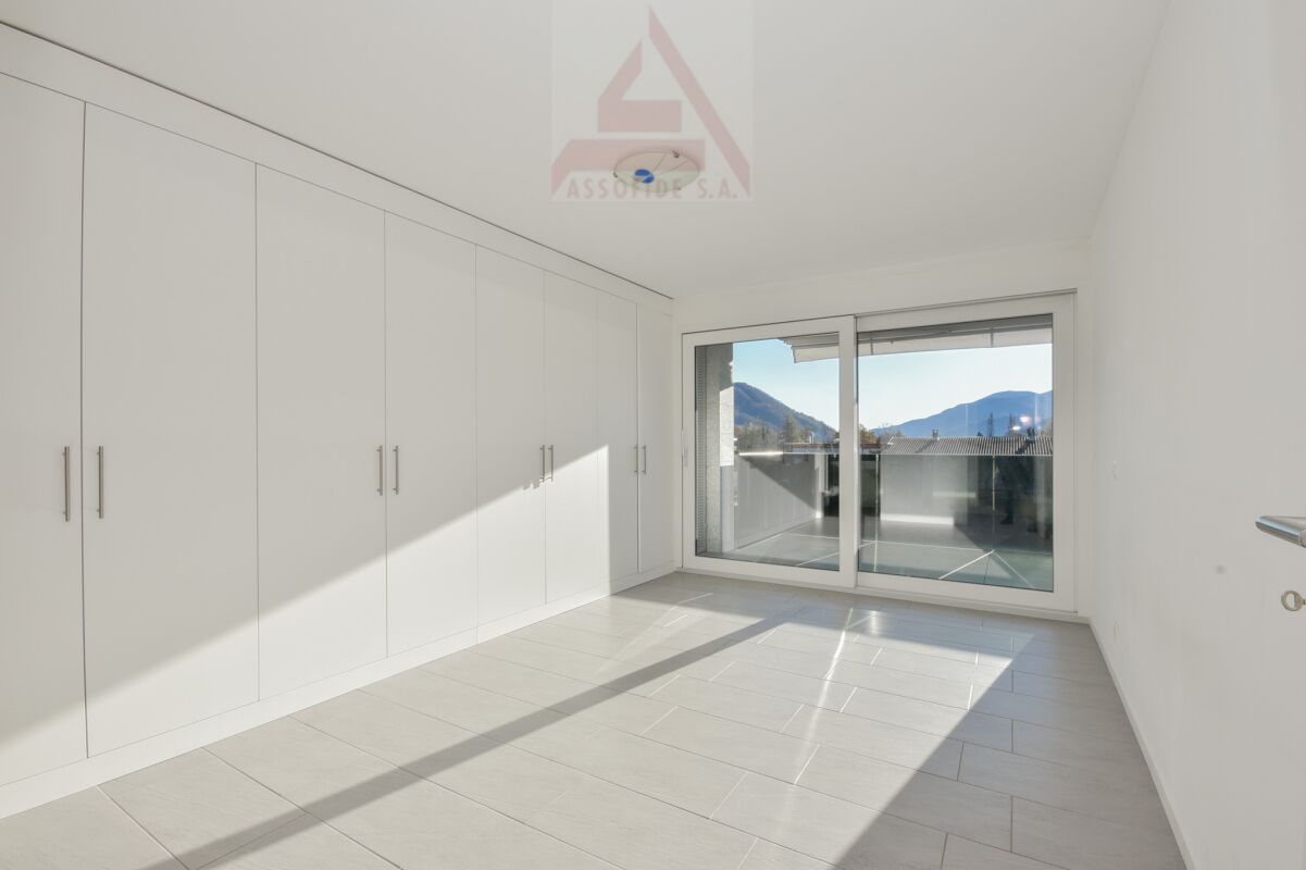 Helles Schlafzimmer mit Einbauschrank und Balkonblick