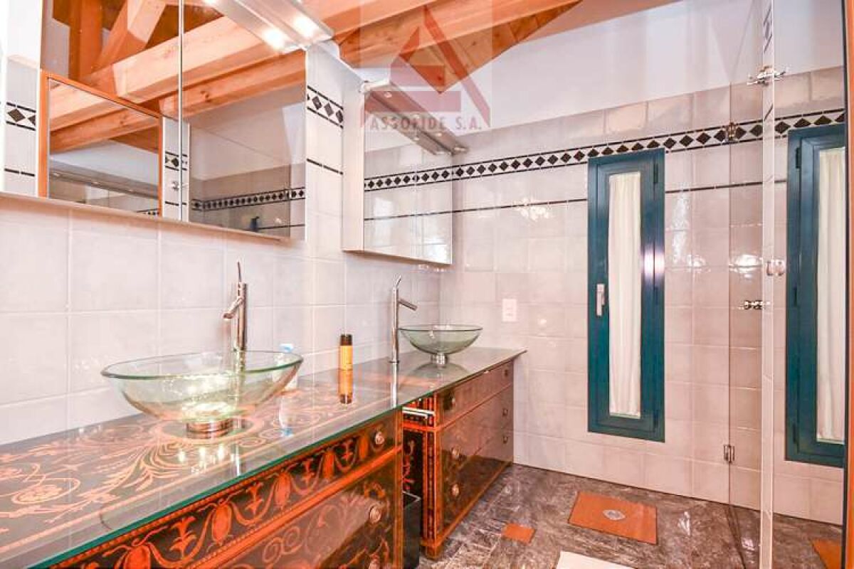 Modernes Badezimmer mit Glaswaschbecken und dekorativen Spiegeln