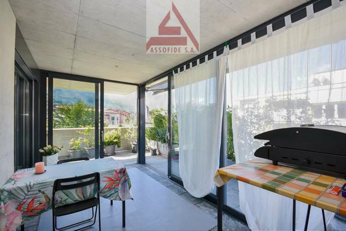 Überdachte Terrasse mit Glasfront und Gartenblick