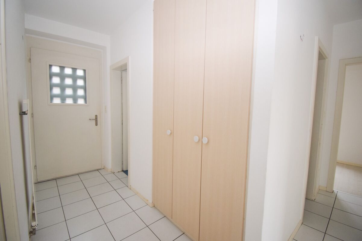 Heller Flur mit Eingangstür und Einbauschrank