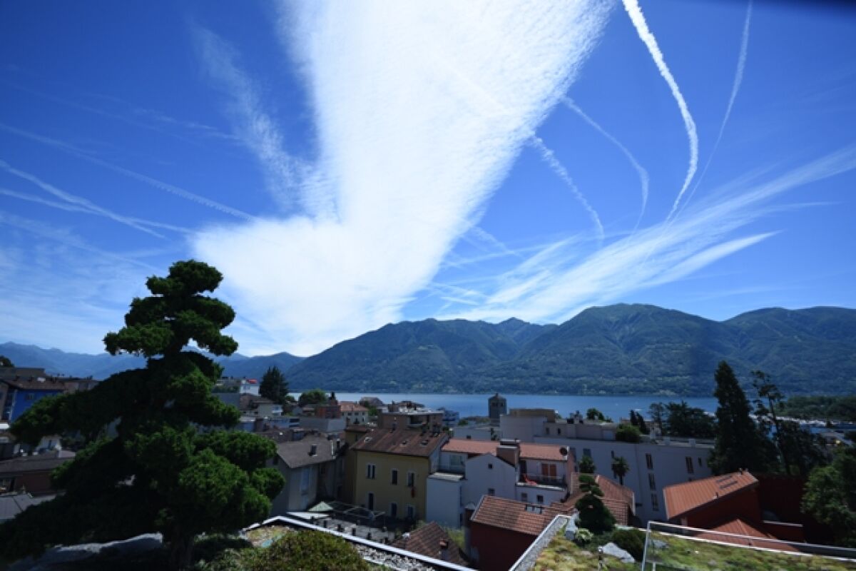 Seeblick mit Bergen und Stadtdächern