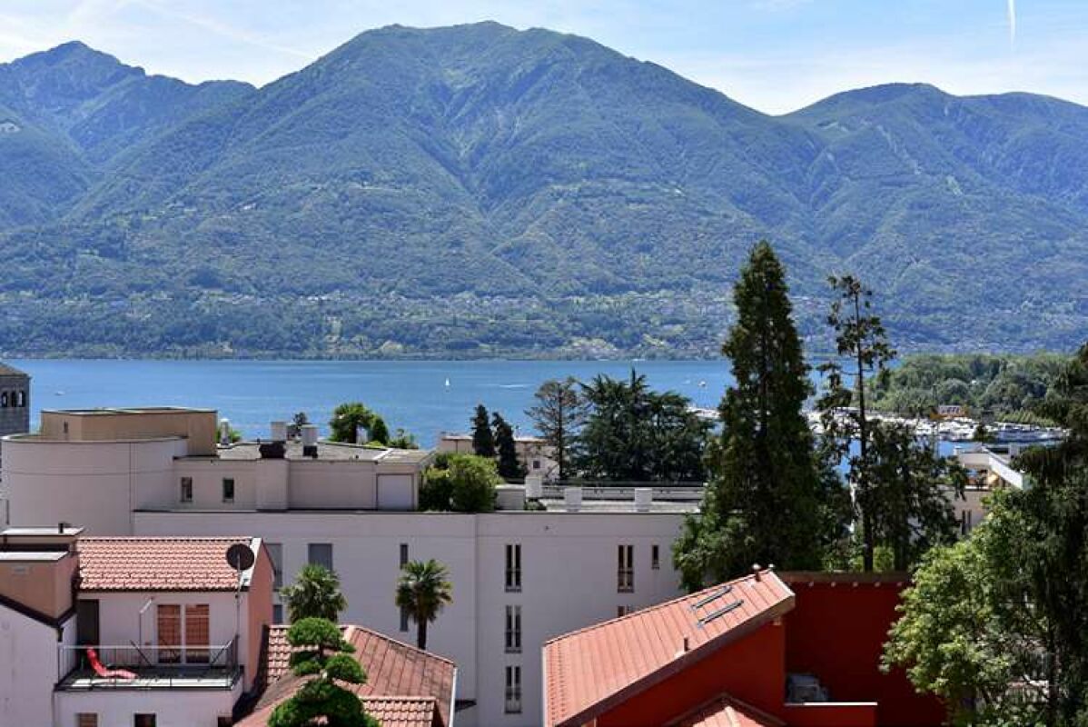 Seeblick mit Bergen und Häusern