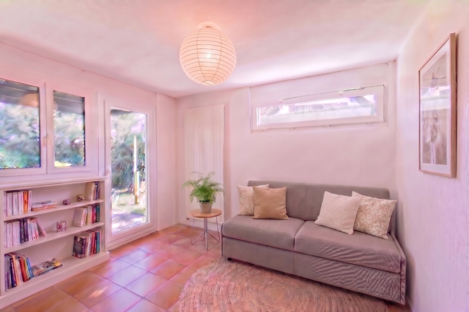 Heller kleiner Wohnraum mit Sofa und Bücherregal