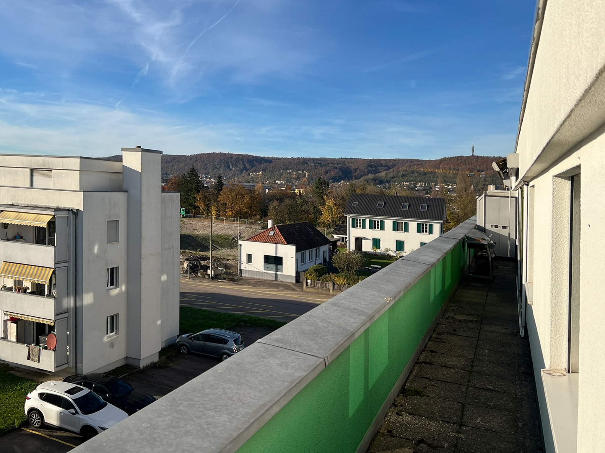 Balkon mit Ausblick auf Wohngebiet und Hügel