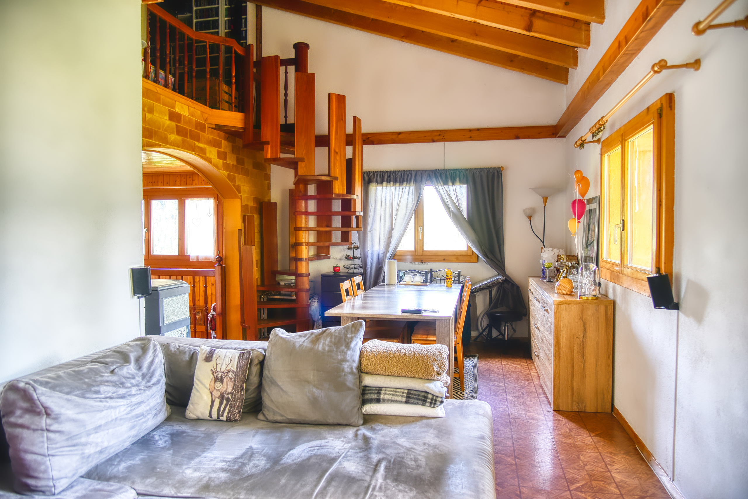 Gemütlicher Wohnbereich mit Holztreppe und Dachbalken
