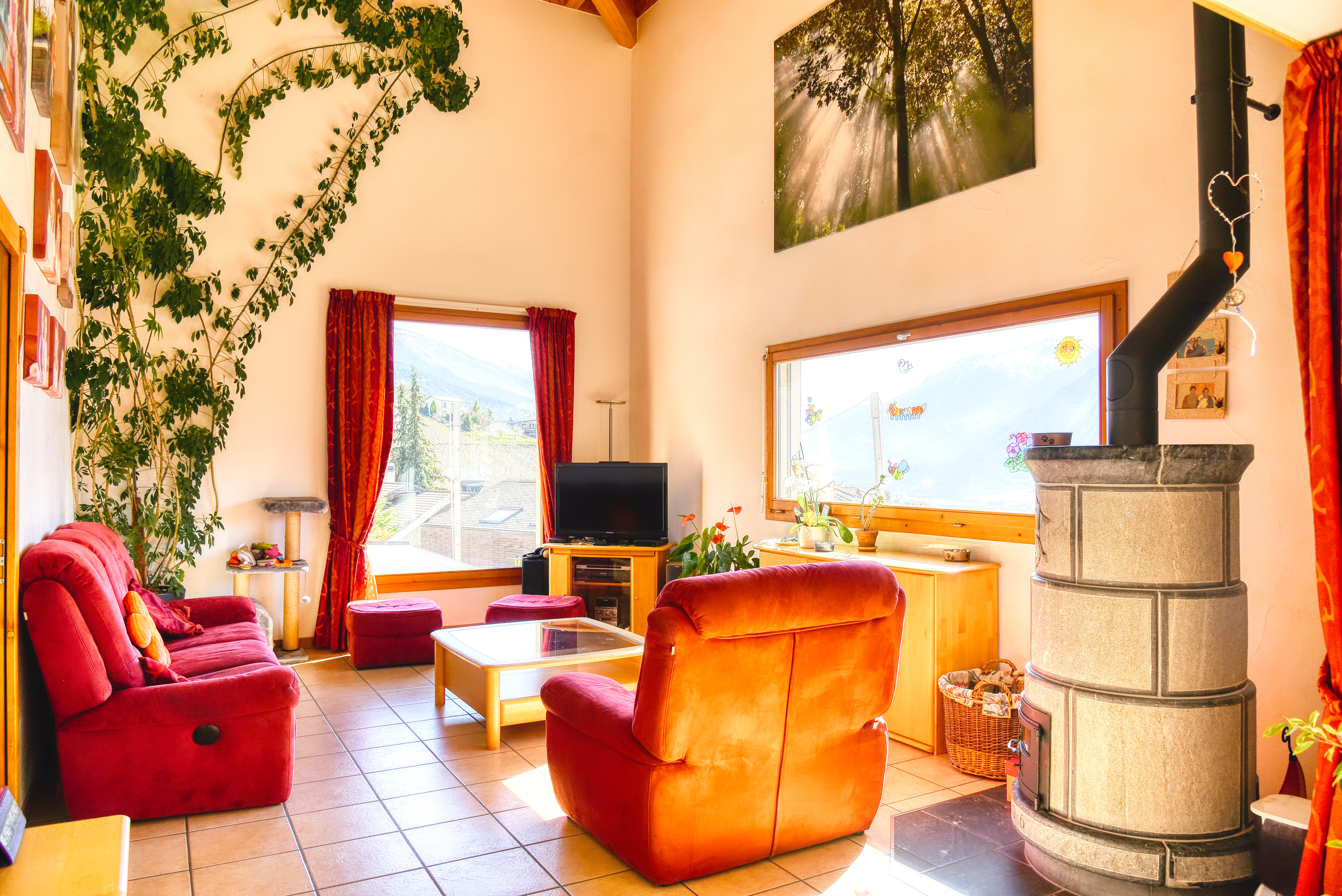 Wohnzimmer mit Kaminofen und großen Fenstern