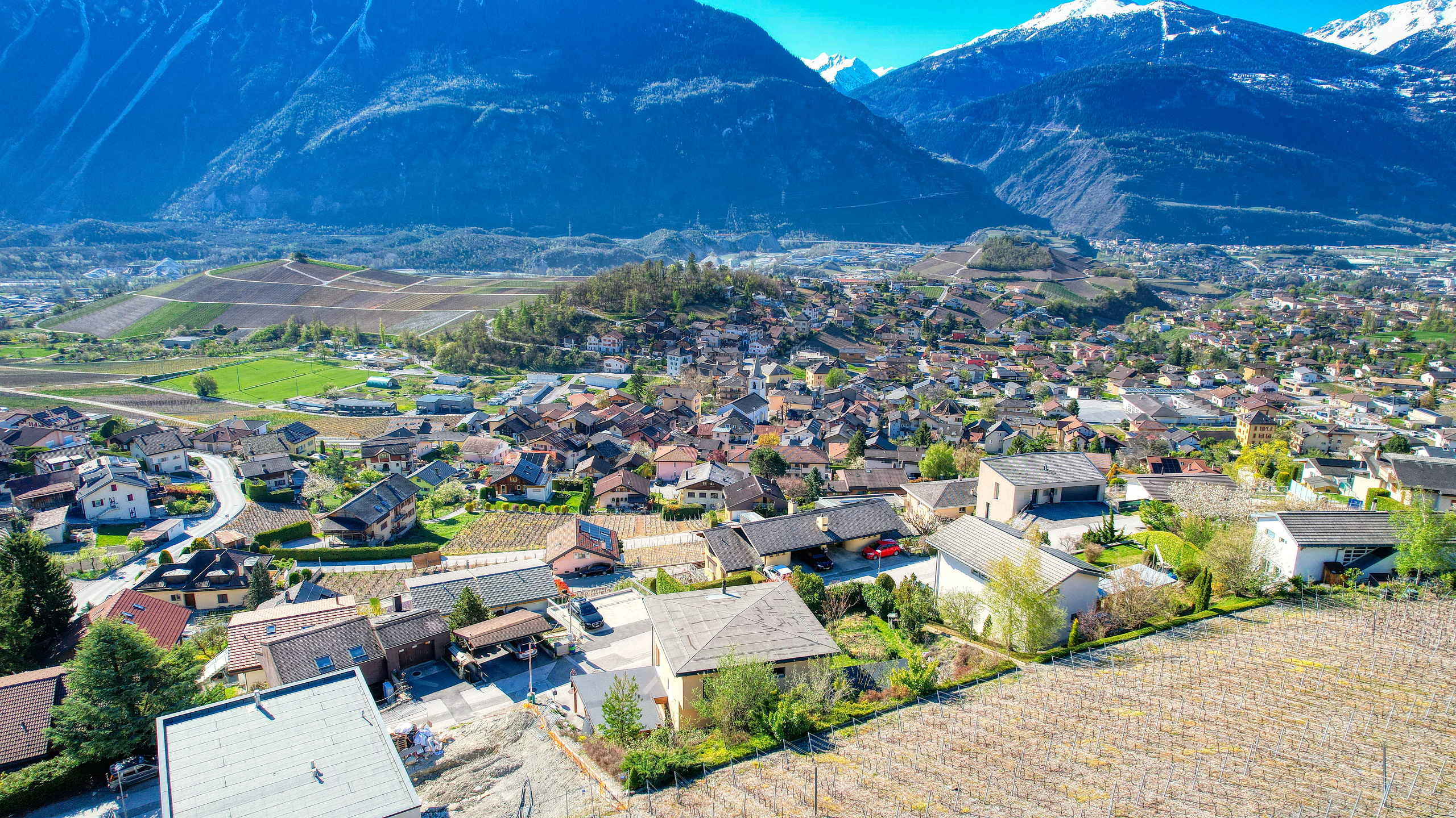Panoramablick über ein Tal mit Dorf und Bergen