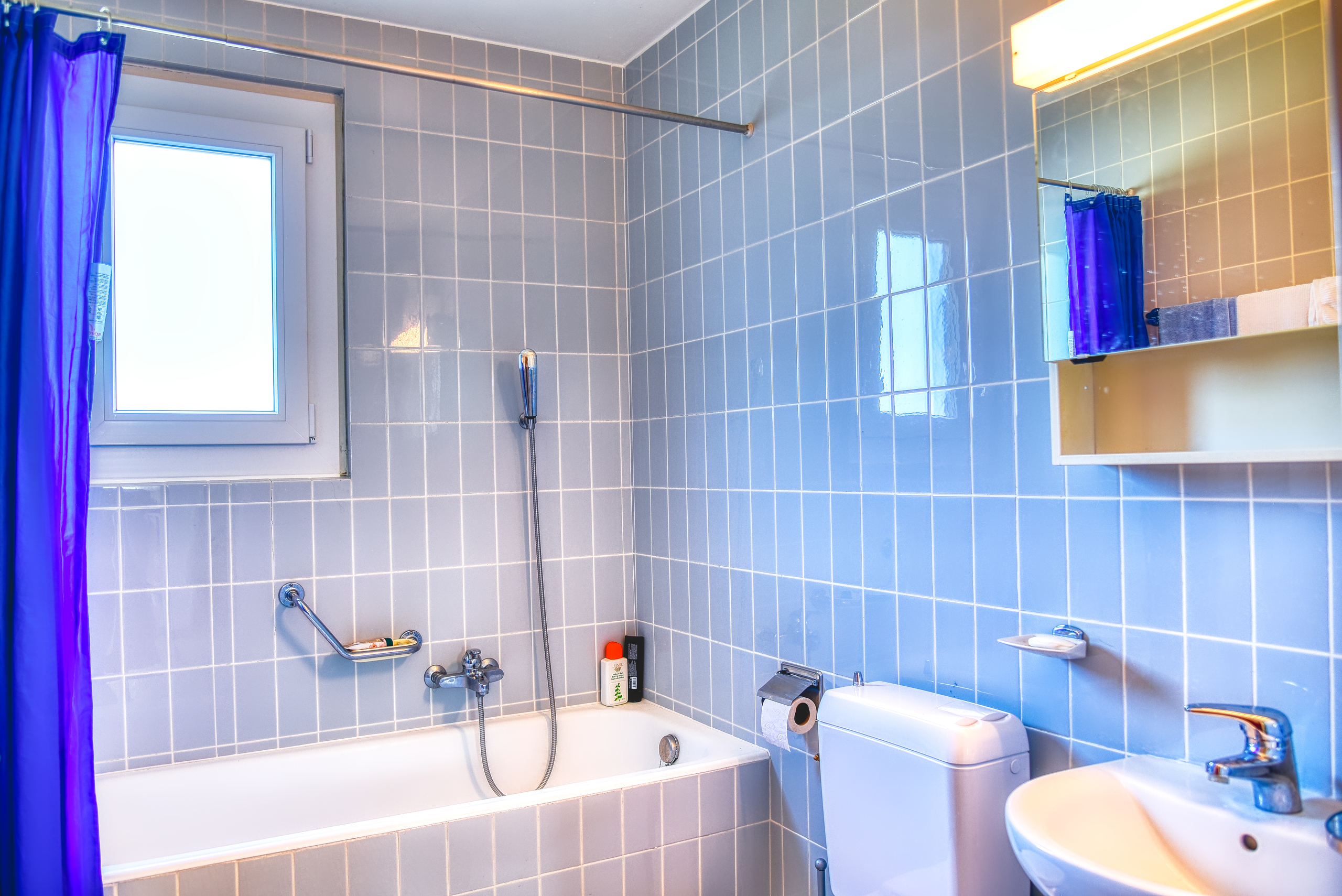 Badezimmer mit hellblauen Wandfliesen
