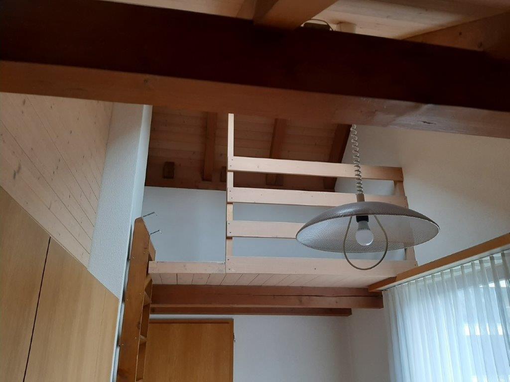 Galerieraum mit Holzbalken und Hängeleuchte