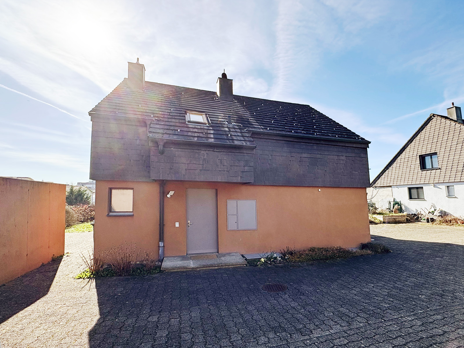 Einfamilienhaus mit dunklem Dach und verputzter Fassade