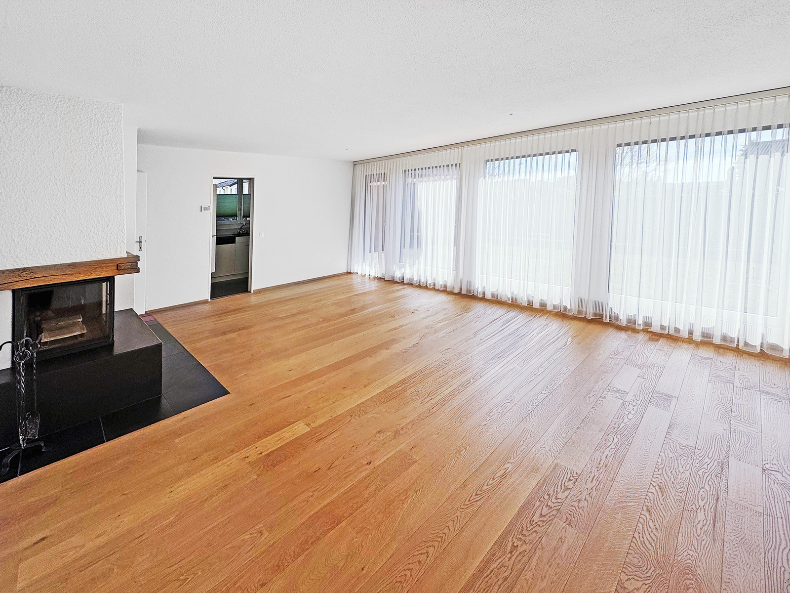 Heller Wohnraum mit Kamin und Panoramafenstern