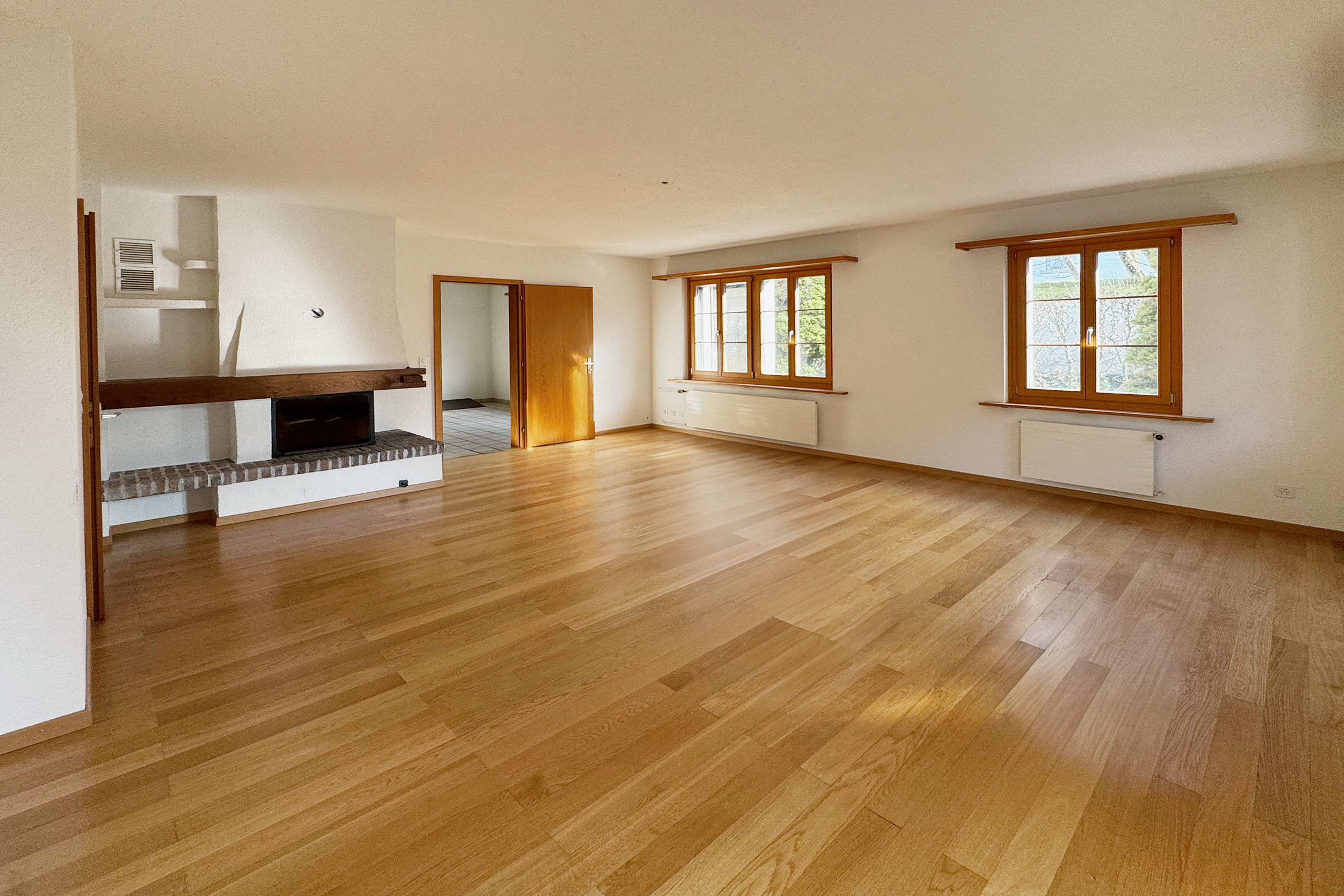 Heller Wohnraum mit Kamin und Parkettboden