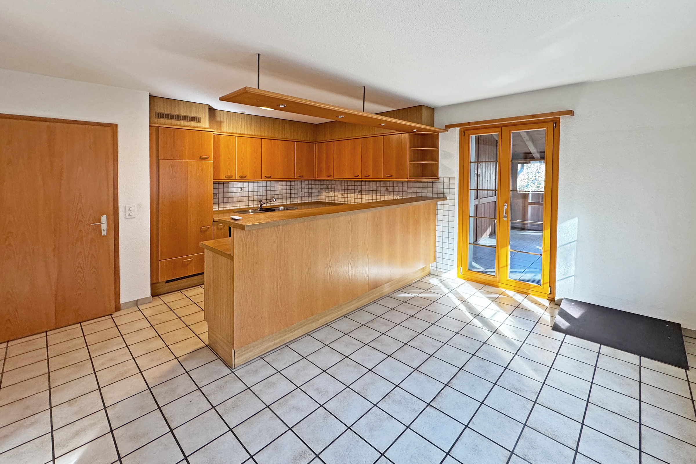 Küche mit Fliesenboden und Holzfronten