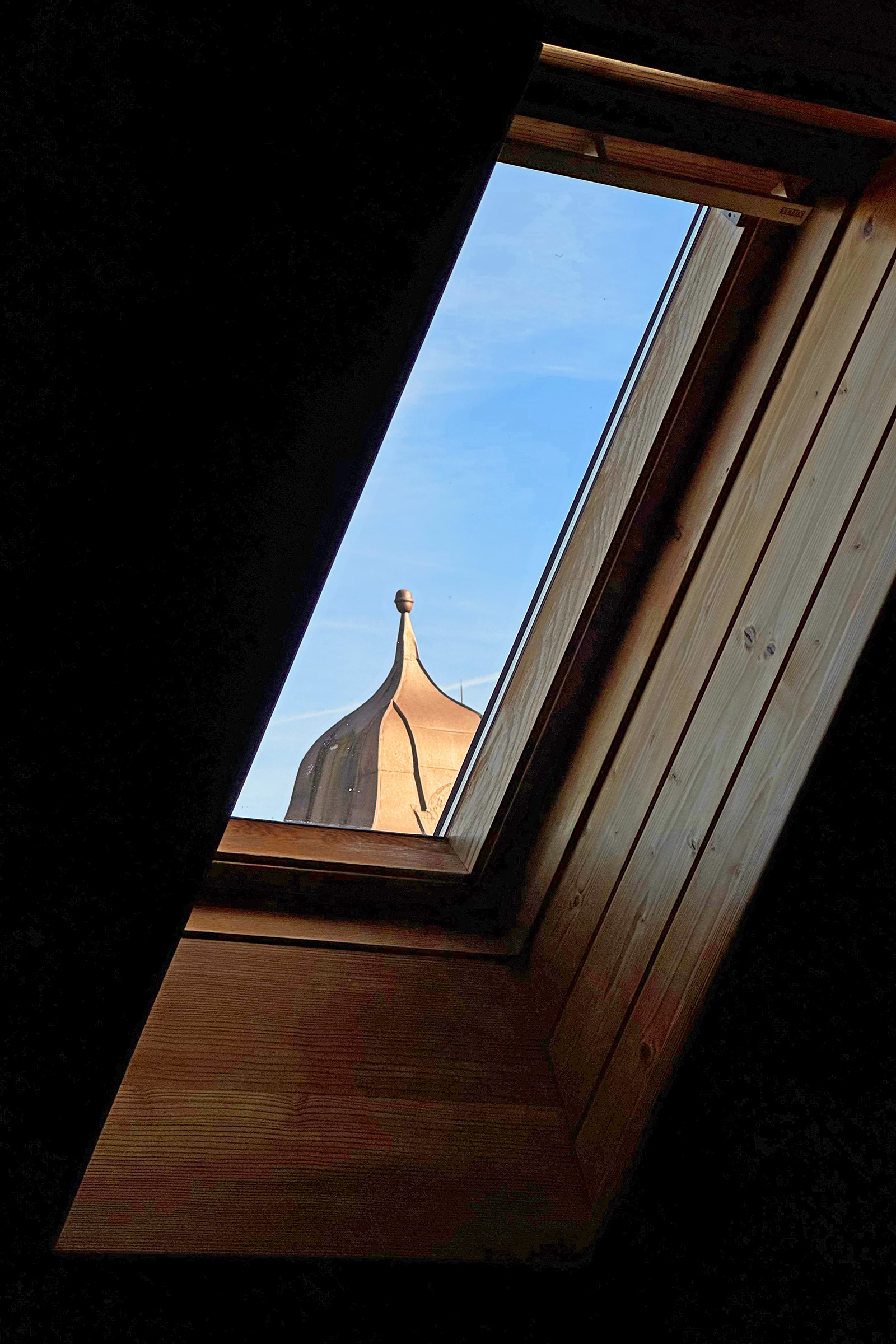 Dachfenster mit Blick auf Kirchturm