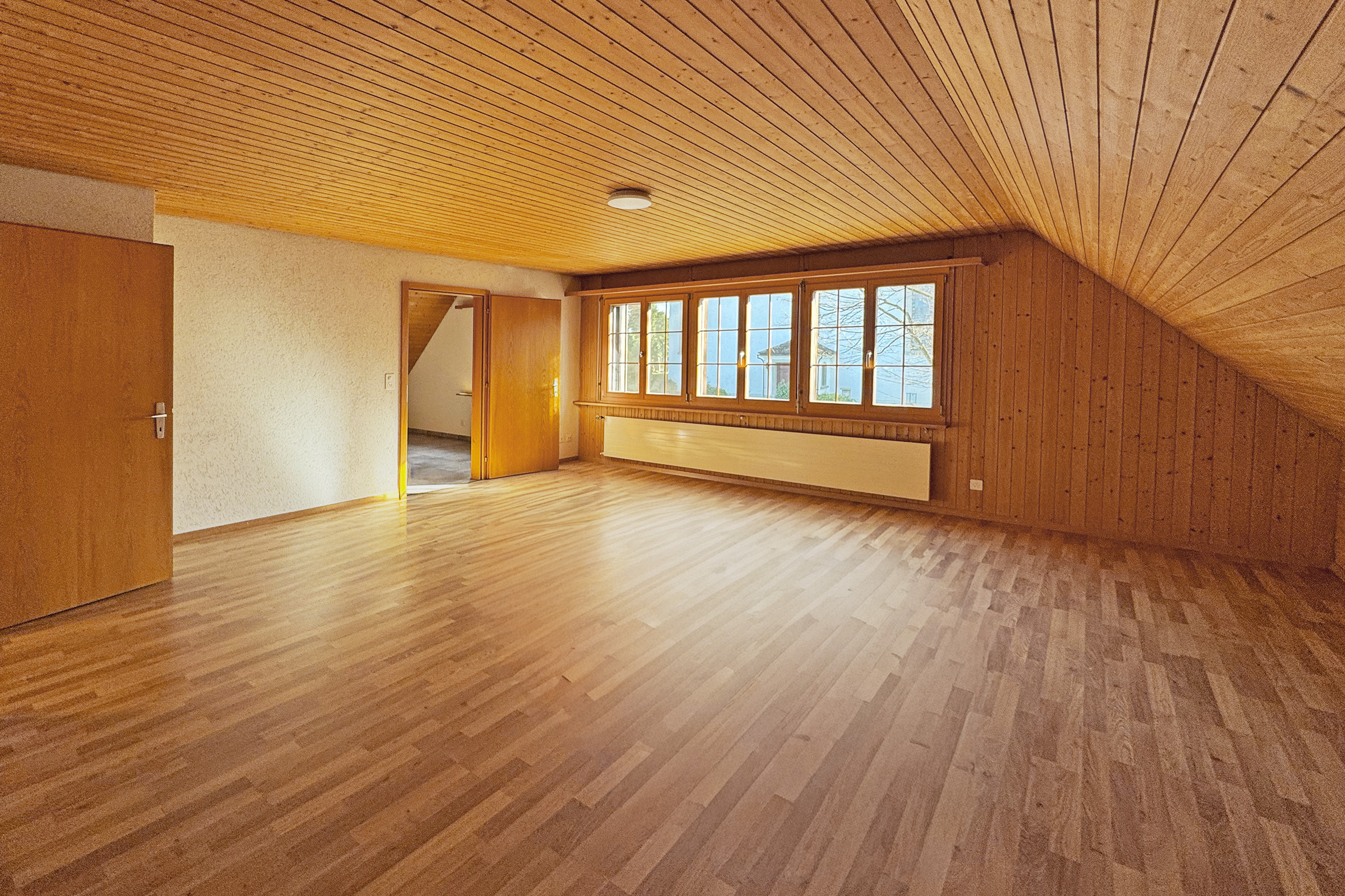 Leeres Dachgeschosszimmer mit Holzverkleidung