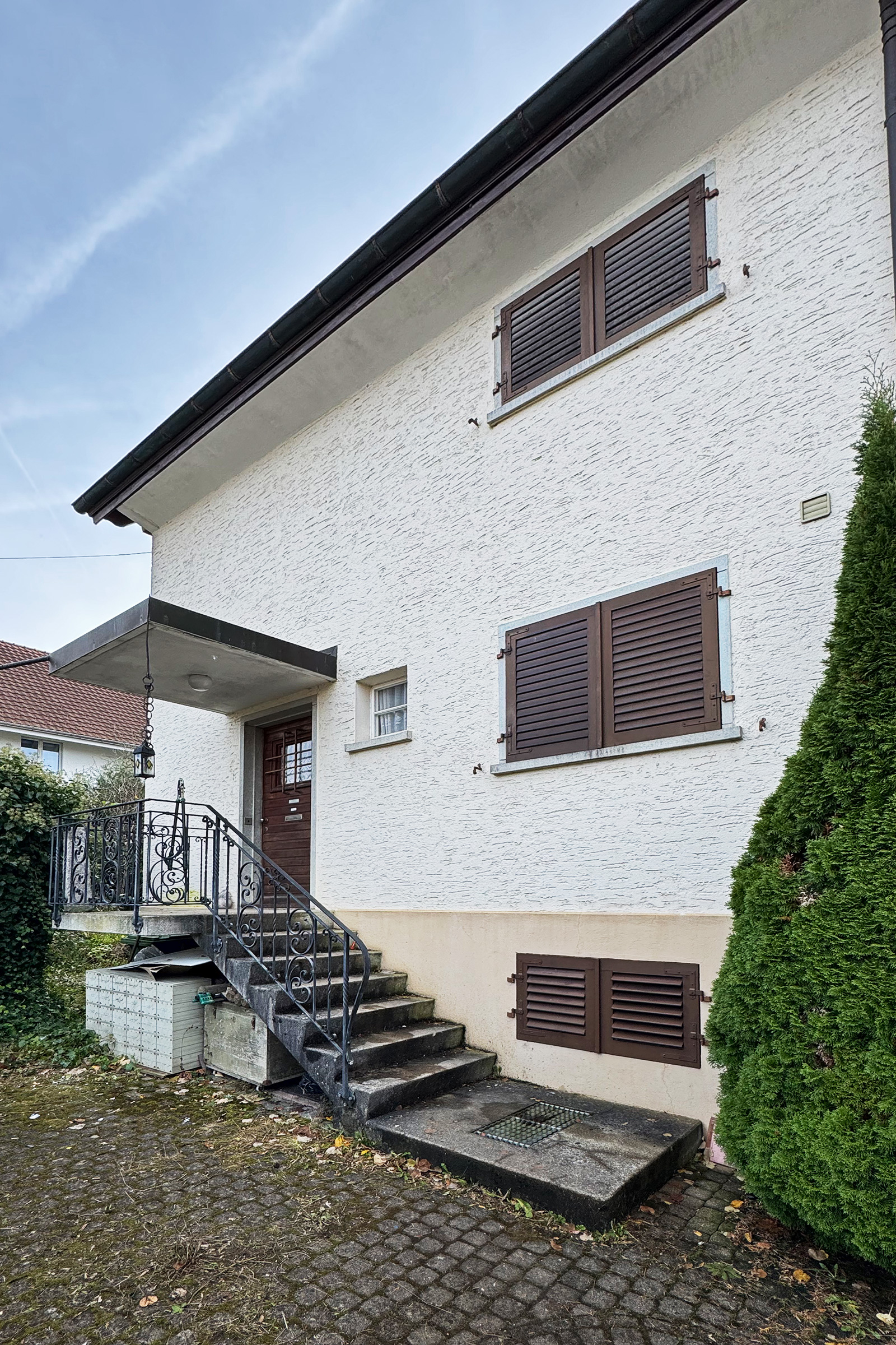 Hausfassade mit Eingang und Fensterläden