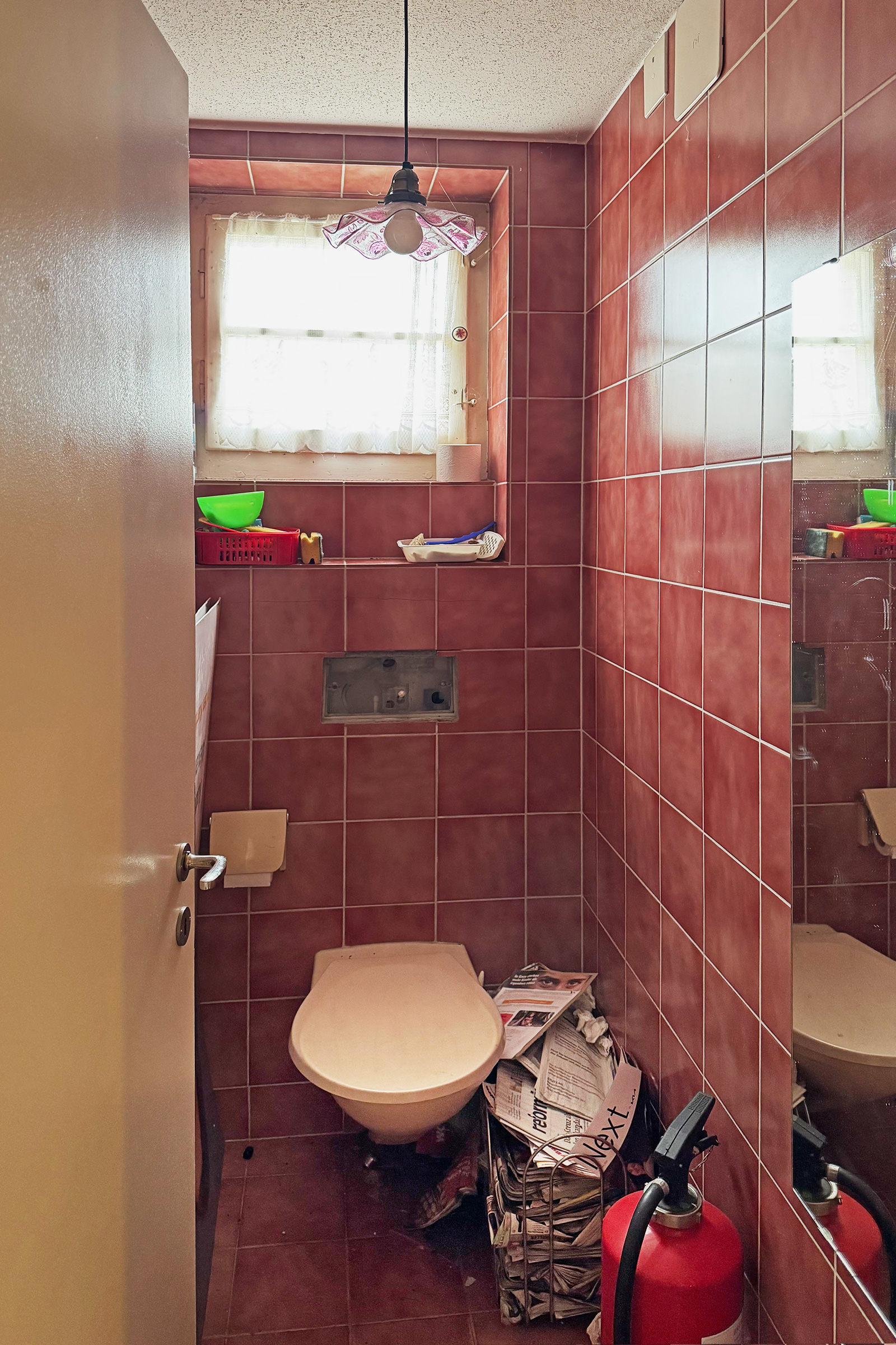 Kleines innenliegendes WC mit roten Fliesen