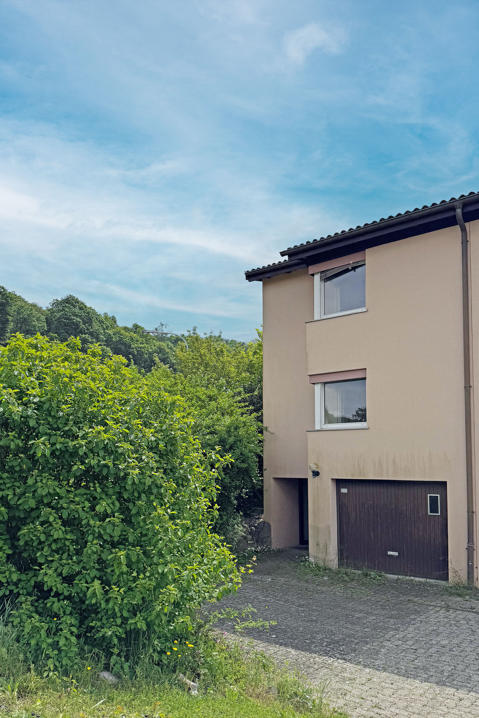 Außenansicht eines Hauses mit Garagenzufahrt