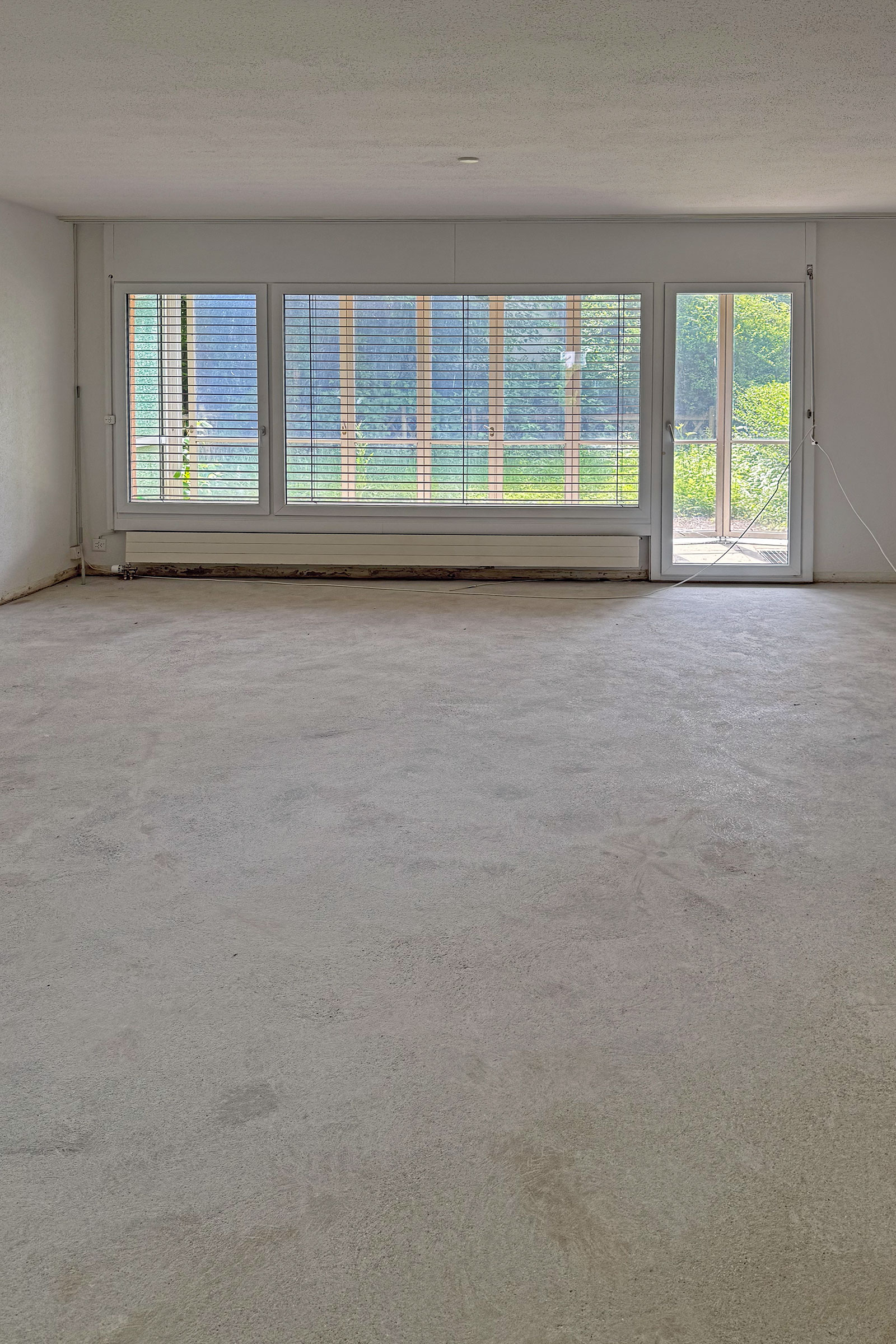 Leerer Wohnraum mit großer Fensterfront