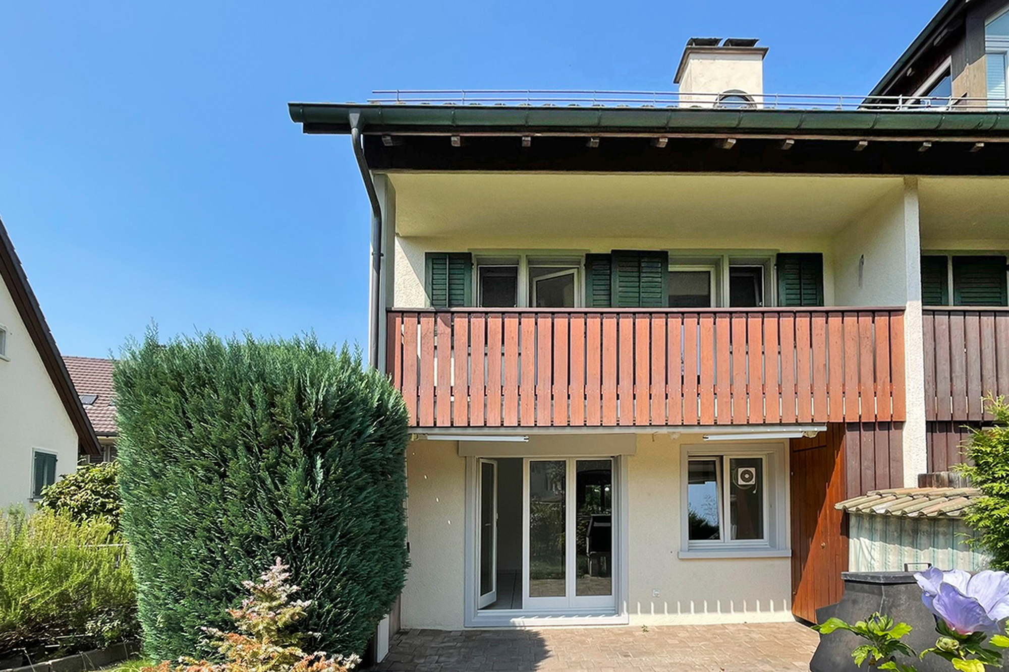 Außenansicht eines Wohnhauses mit Balkon und Garten