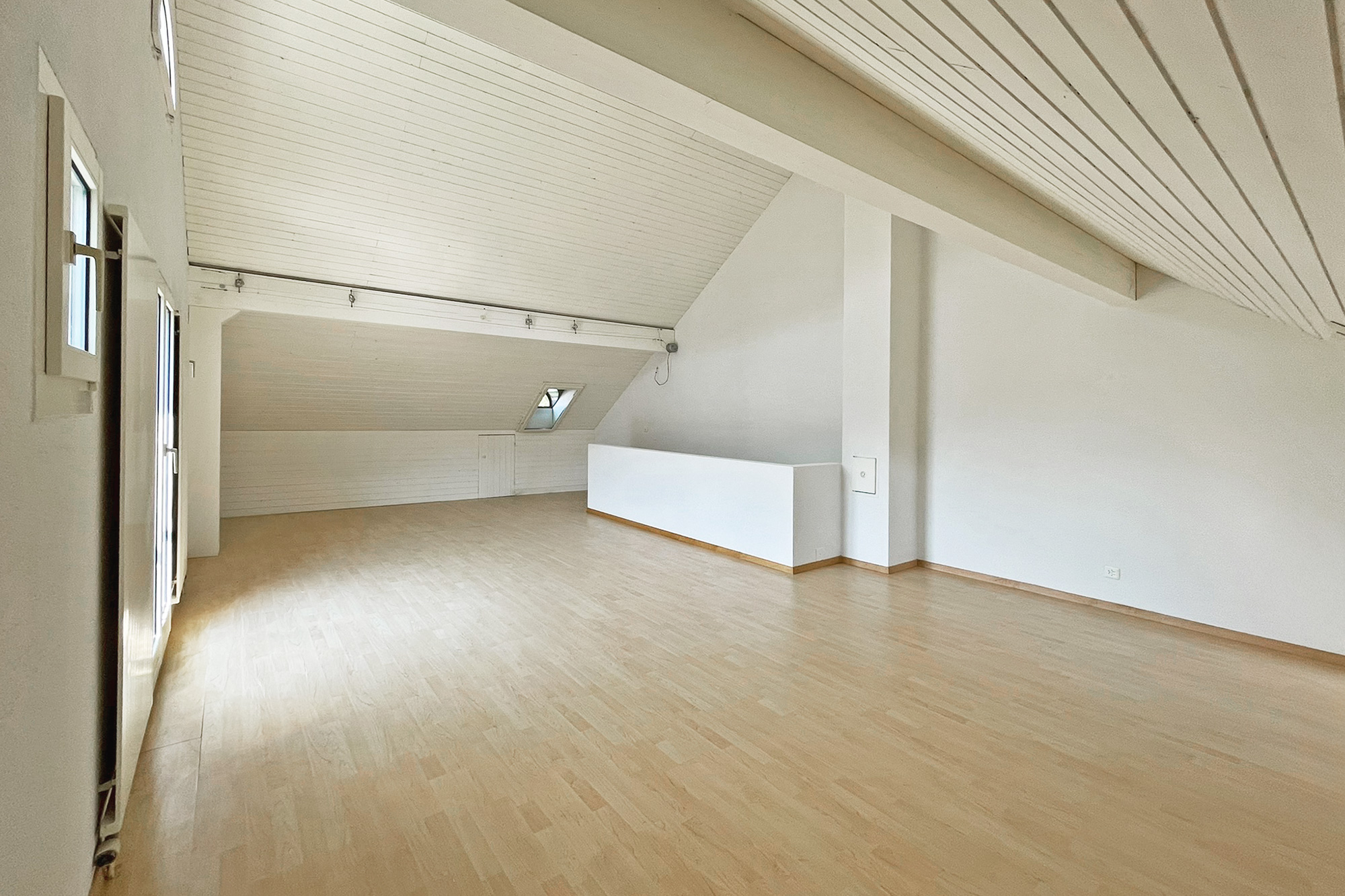 Heller, leerer Dachraum mit Holzdecke