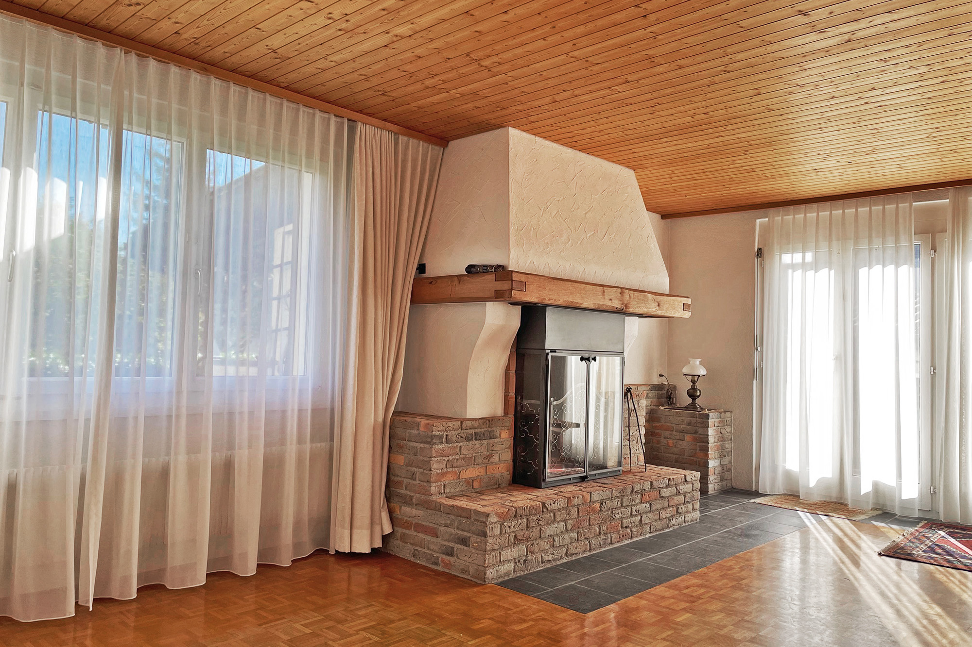 Wohnzimmer mit Kamin und Holzbalkendecke