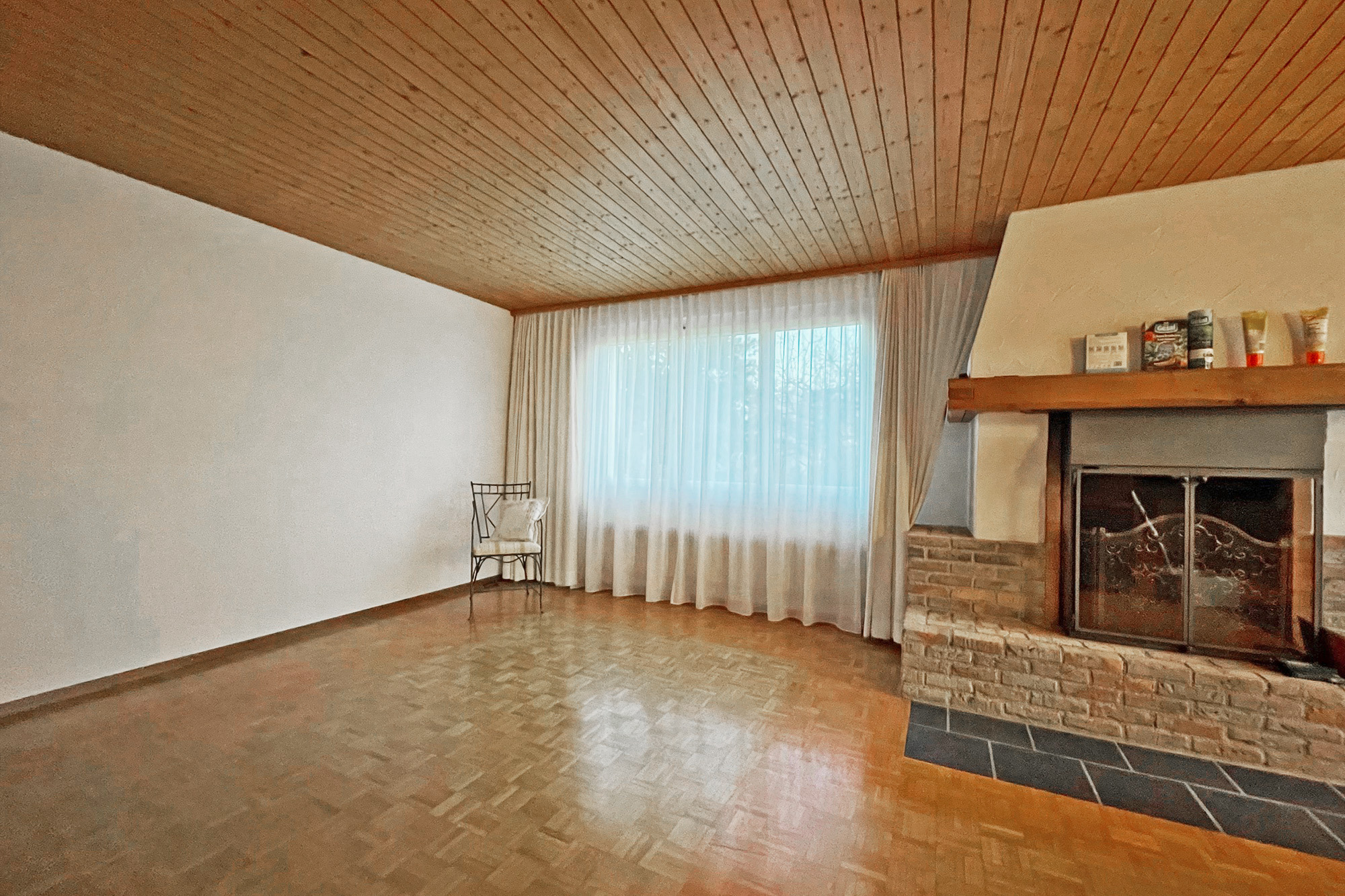 Wohnzimmer mit Kamin und Holzdecke
