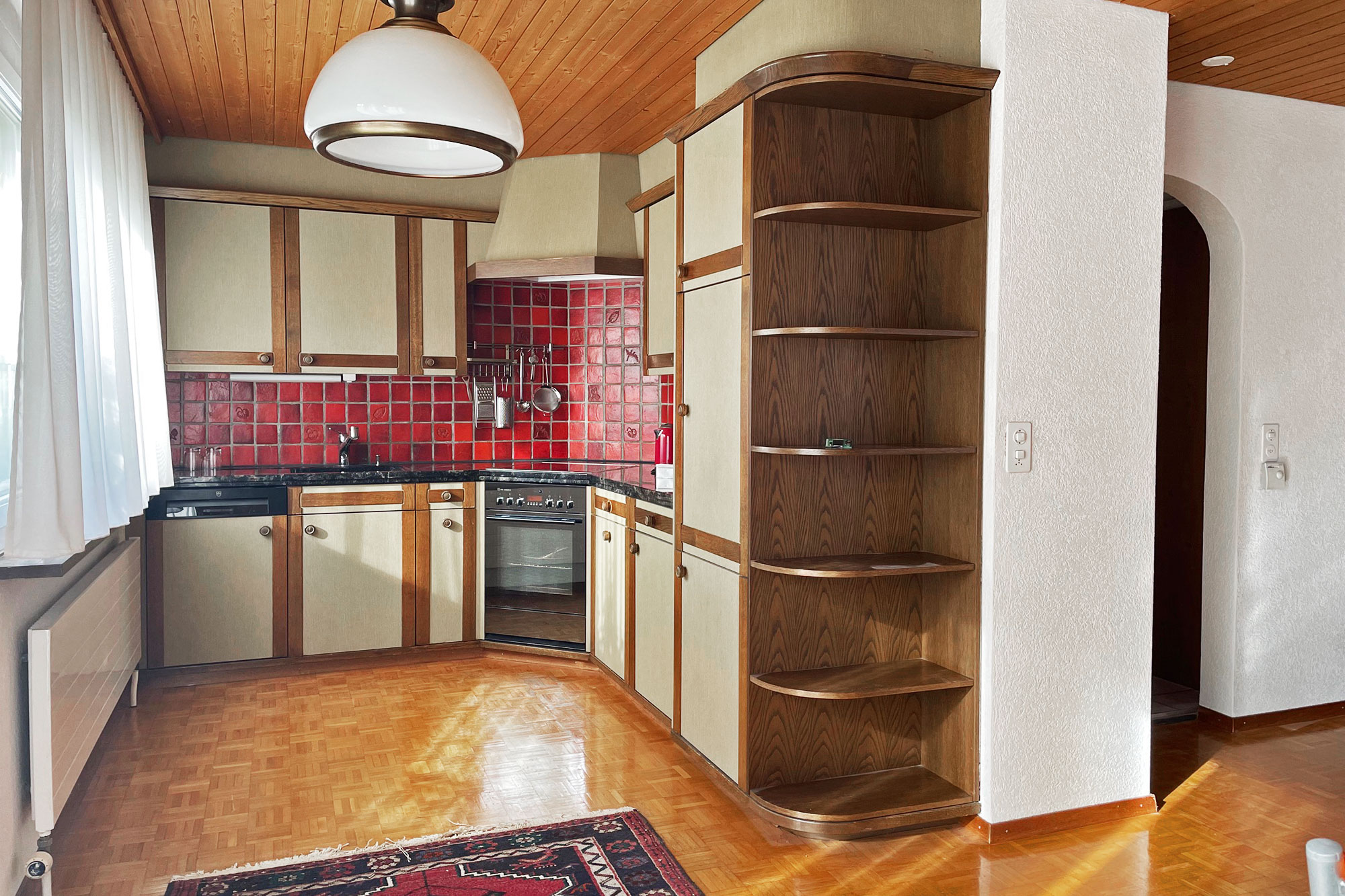 Küche mit Holzdecke und roten Fliesen