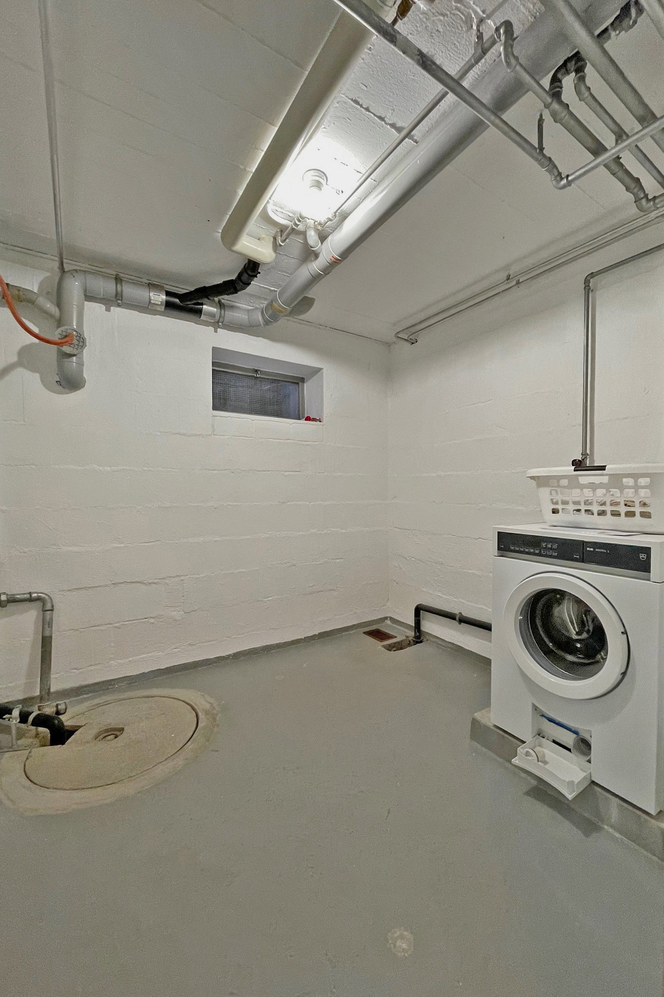Hauswirtschaftsraum mit Waschmaschine und Technikleitungen