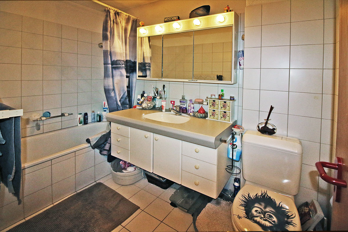 Badezimmer mit Badewanne und beleuchtetem Spiegelschrank