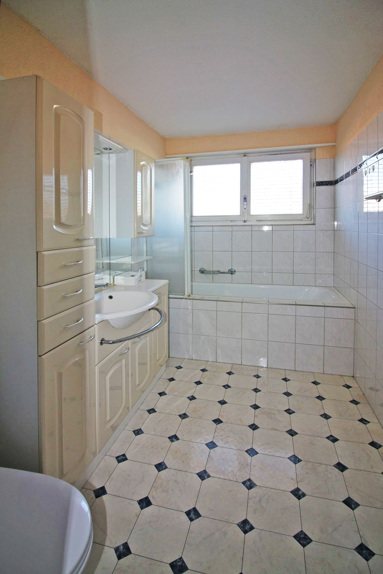 Badezimmer mit Badewanne und Einbauschrank