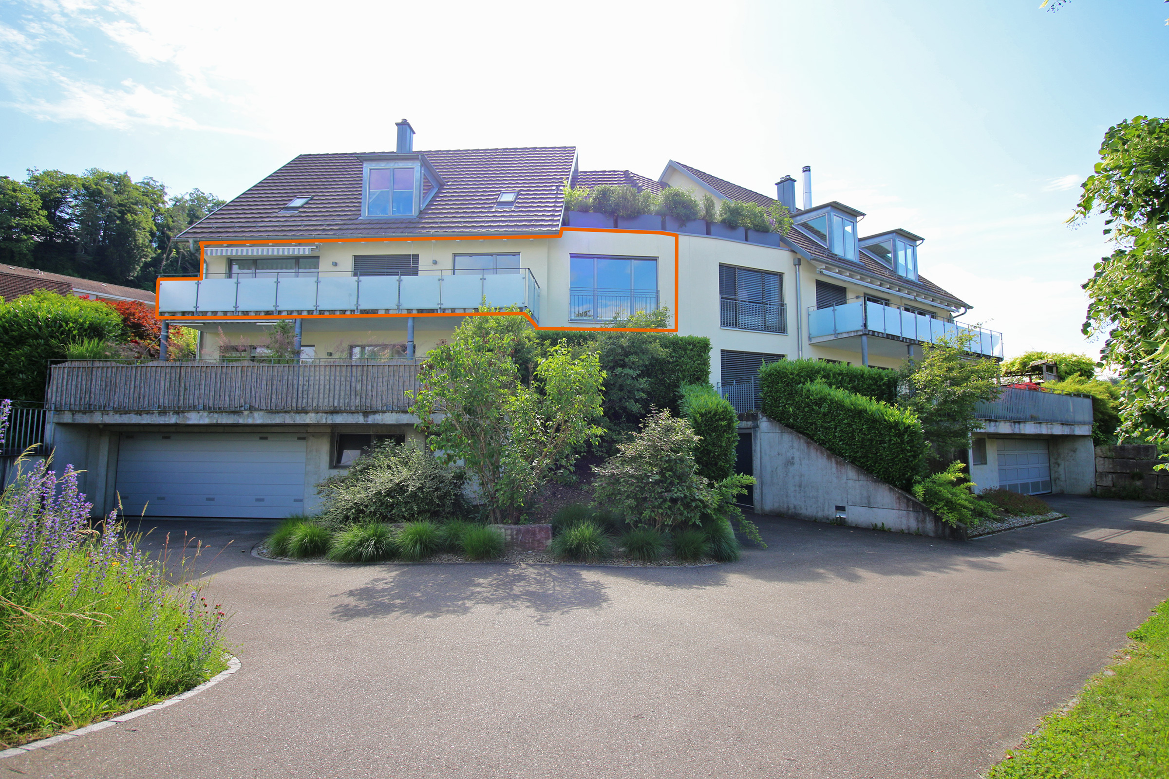 Modernes Mehrfamilienhaus mit Dachgauben und Garagenzufahrten