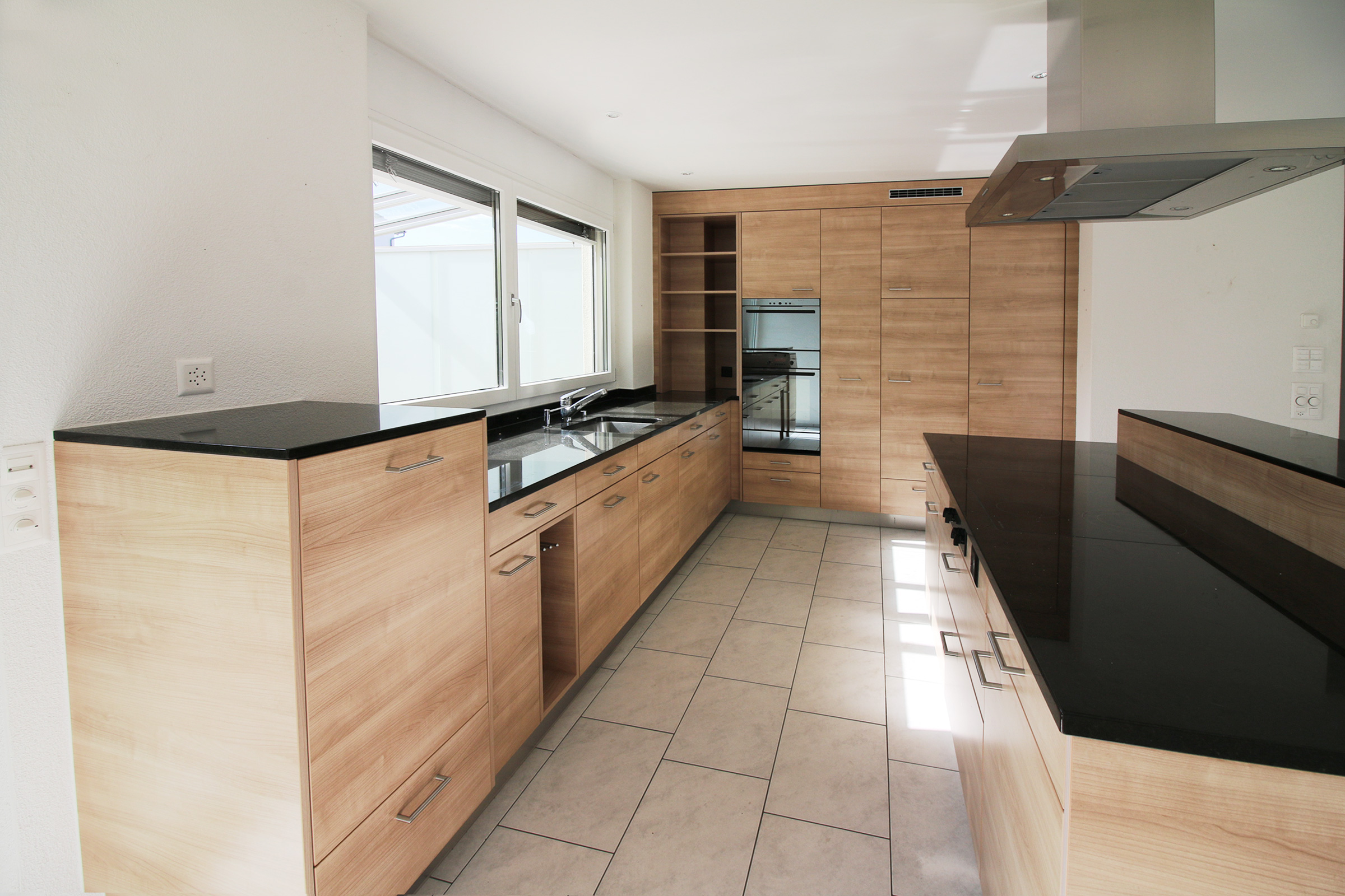 Moderne Küche mit Holzfronten und schwarzen Arbeitsplatten