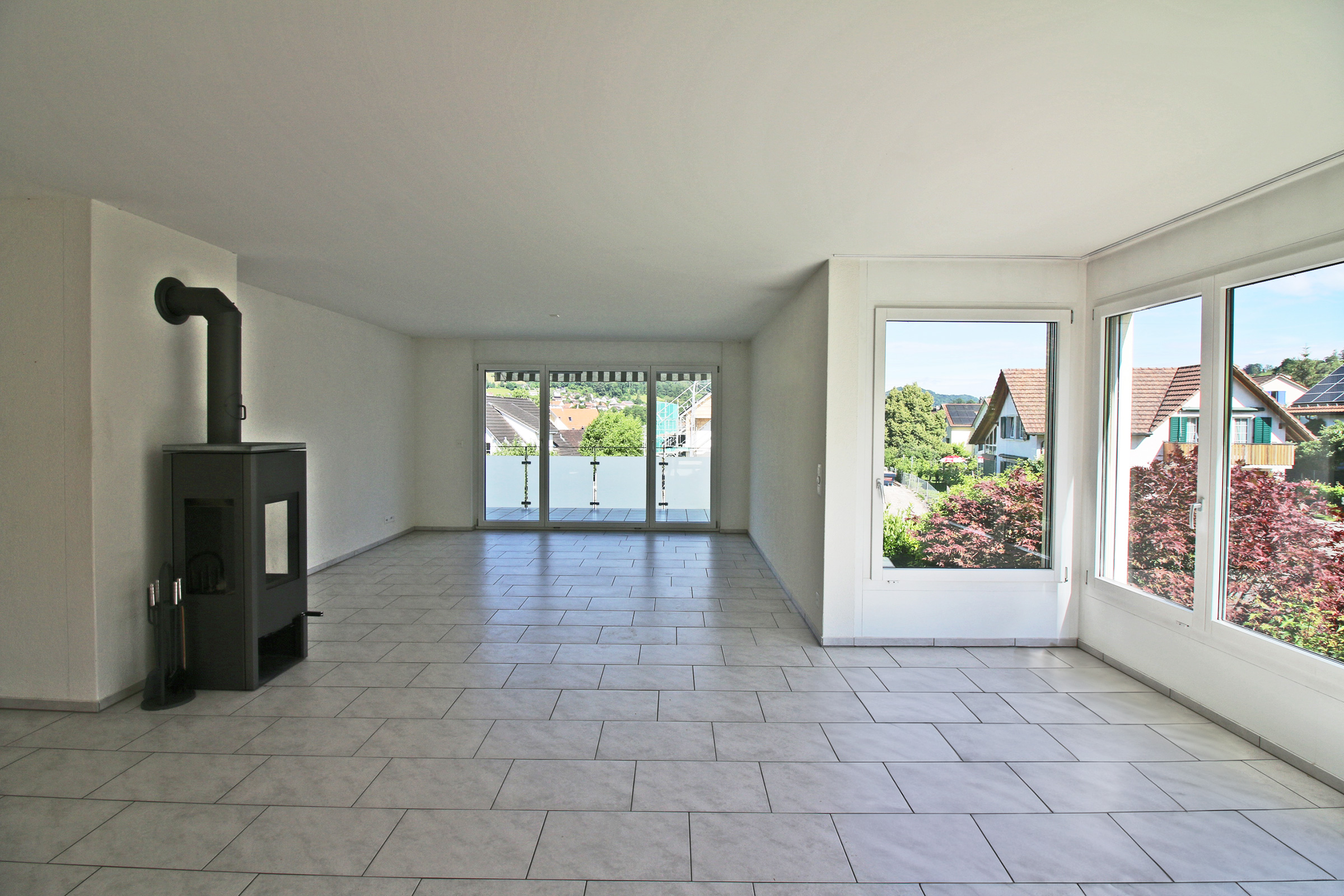 Heller Wohnraum mit Kamin und Balkonblick