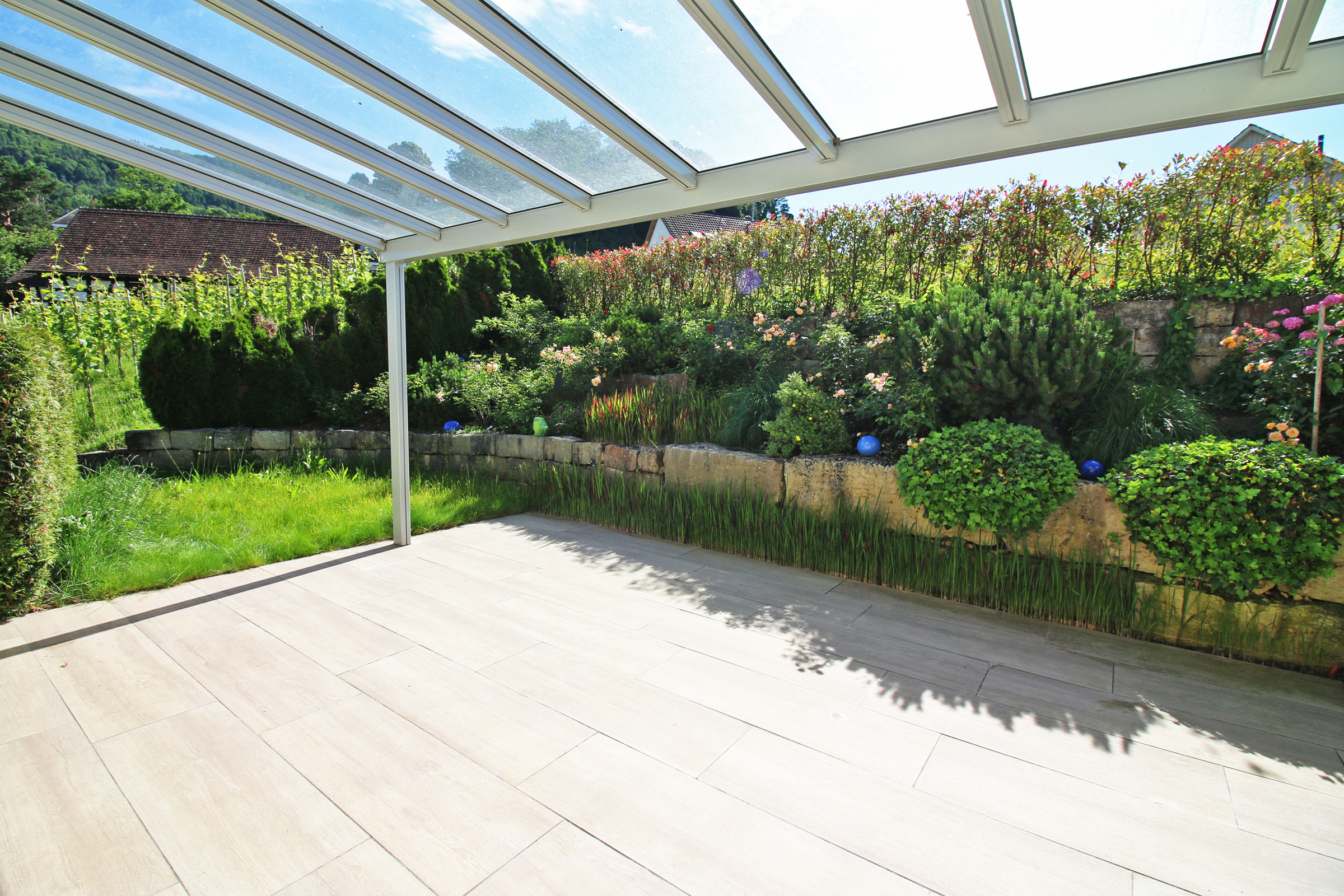 Überdachte Terrasse mit Gartenblick